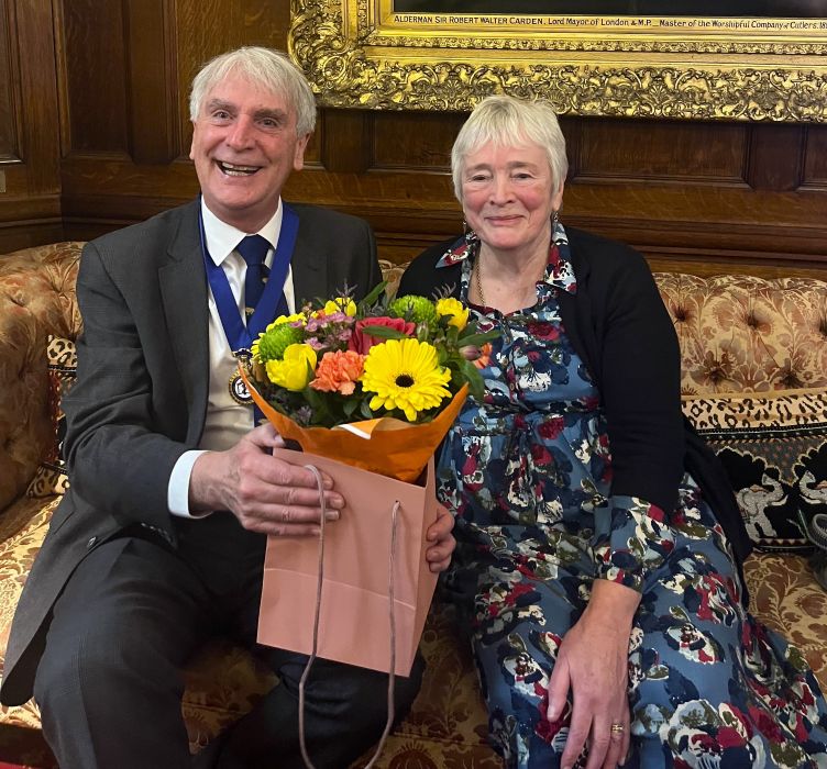 Peter Dyer and Margaret Wilson with flowers on a sofa